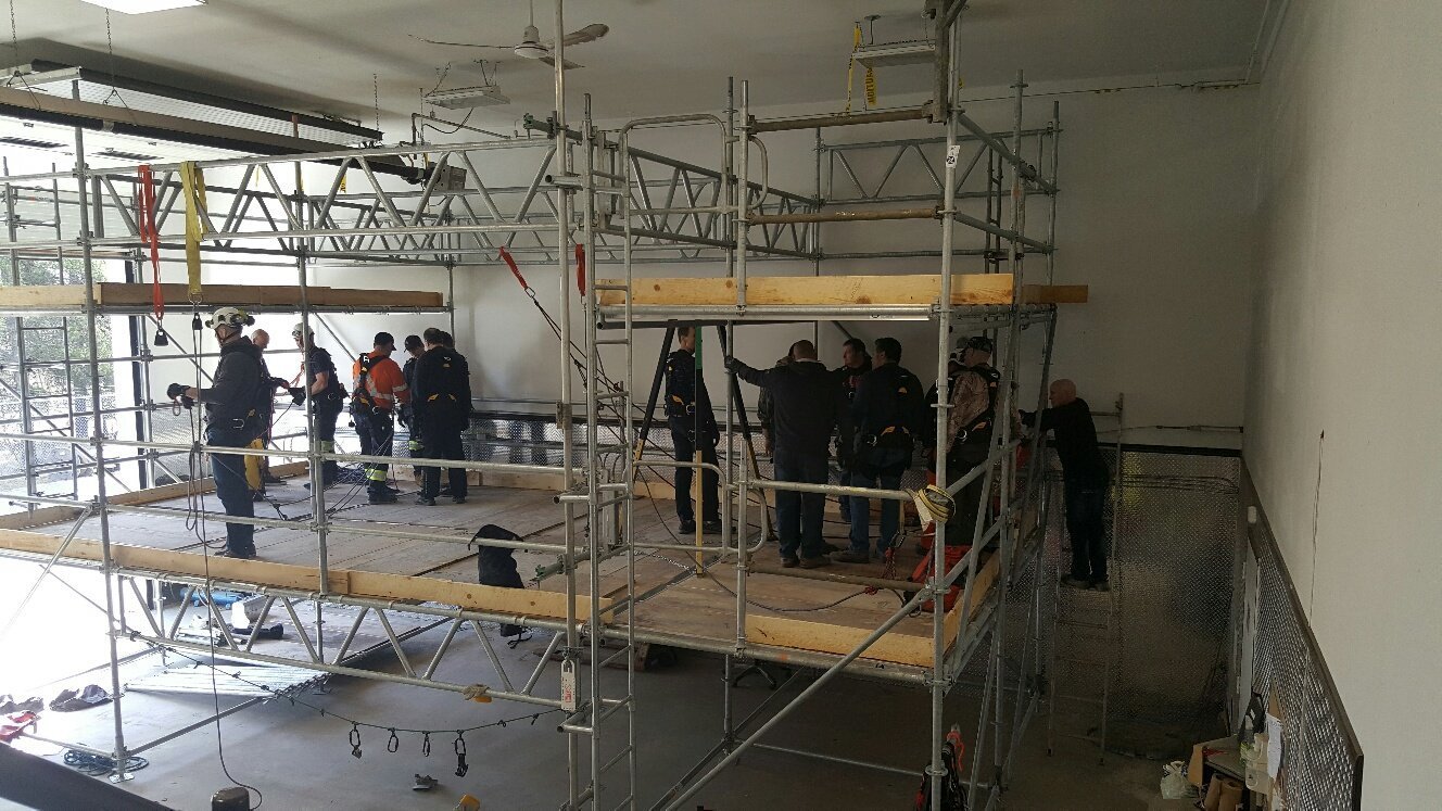 A group of scaffolders working indoors.